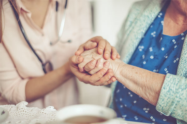 nurse and patient holding hands