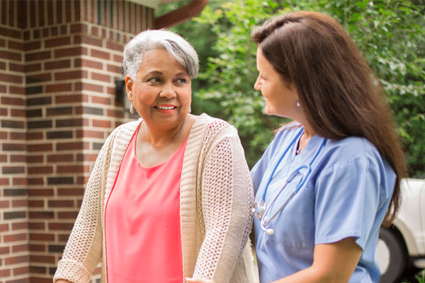 nurse walking with patient outside