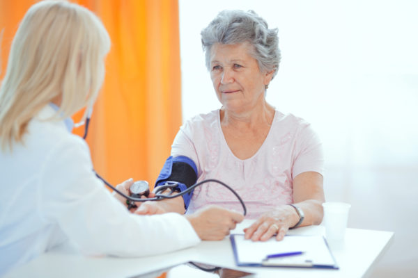 senior woman getting blood pressure checked on Wellness Fair