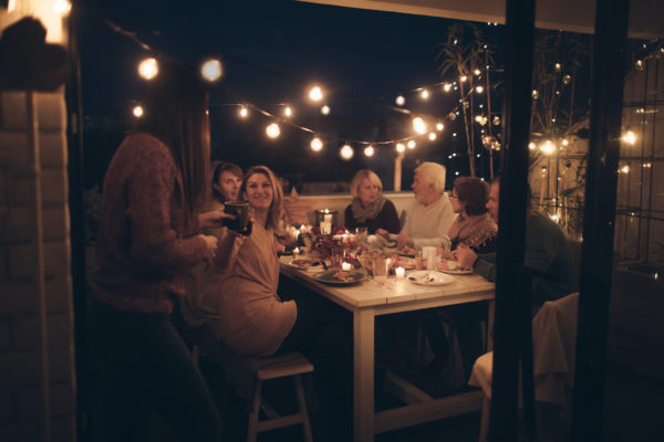 Multi-generation family having Thanksgiving dinner outdoors on their balcony
