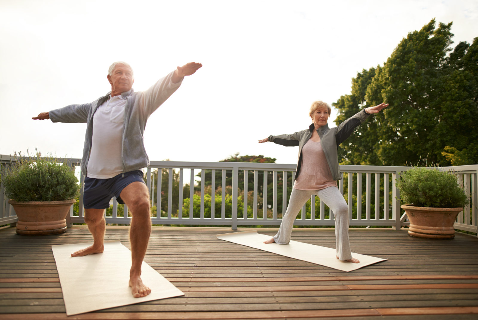senior married couple practicing yoga at home