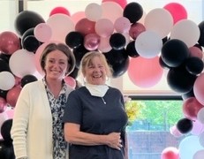 Jessica and Maureen celebrate their awards with balloons in the background