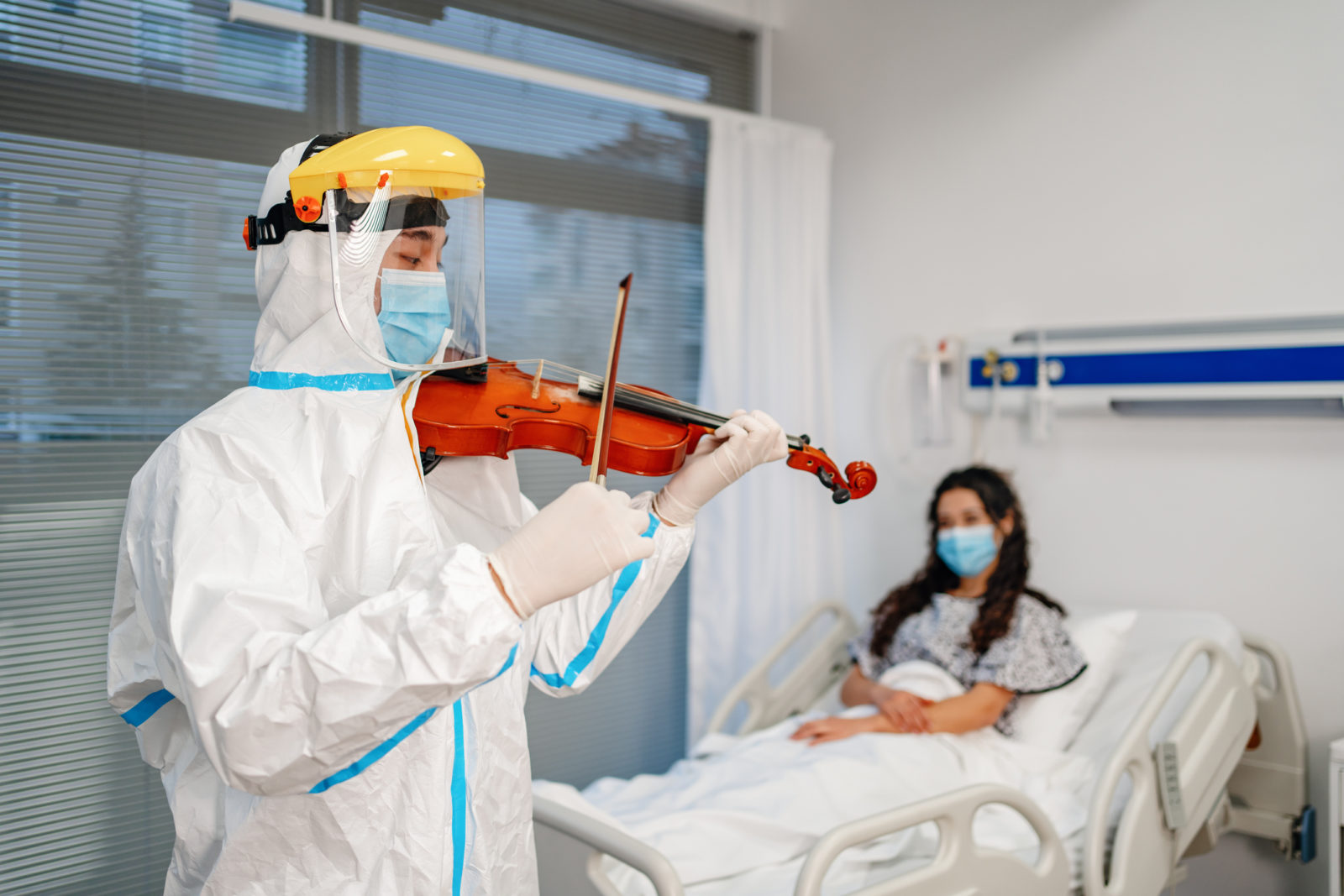 doctor playing violin for patients in hospital