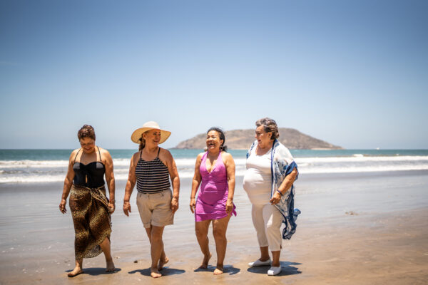 Senior friends talking while walking by the ocean