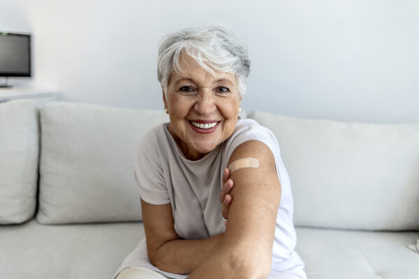 Portrait of a senior woman proudly showing her arm with bandage after getting vaccine.